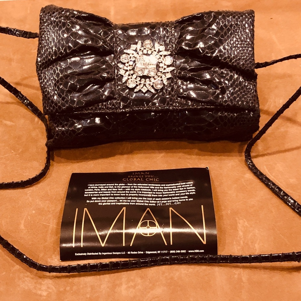 Iman Globed chic bow clutch in black with strap.